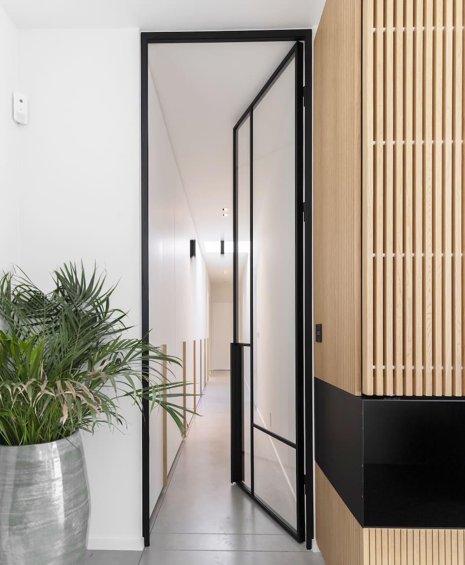 Stalen scharnierdeur met asymmetrische vlakverdeling in zwarte poedercoating